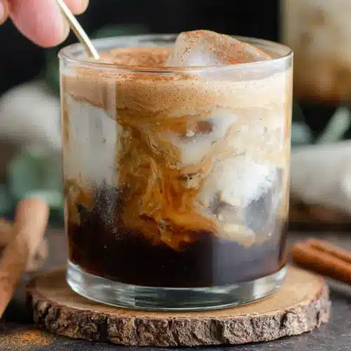 Banana Bread Latte with cinnamon and milk swirls in a glass