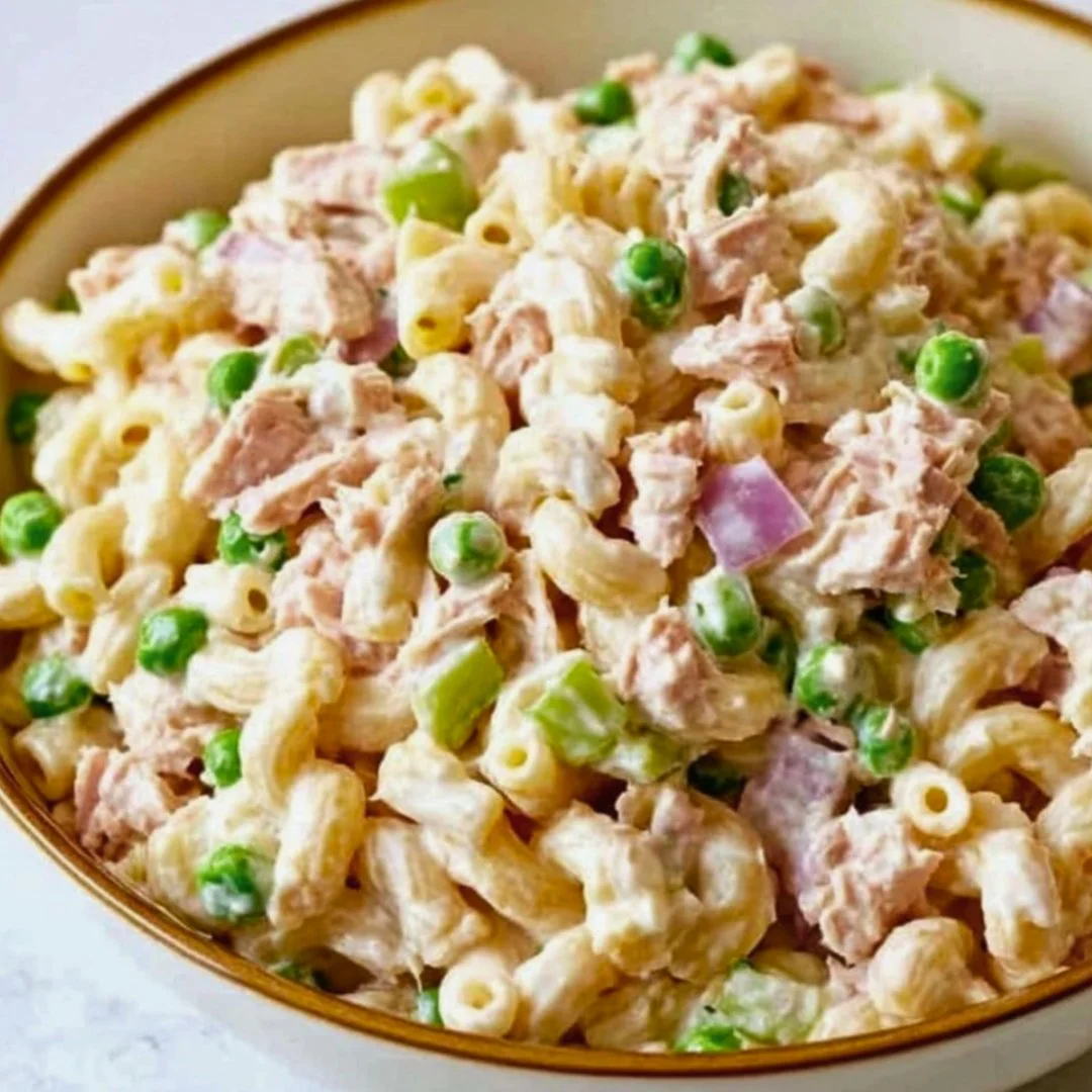 A bowl of colorful tuna pasta salad with vegetables and dressing