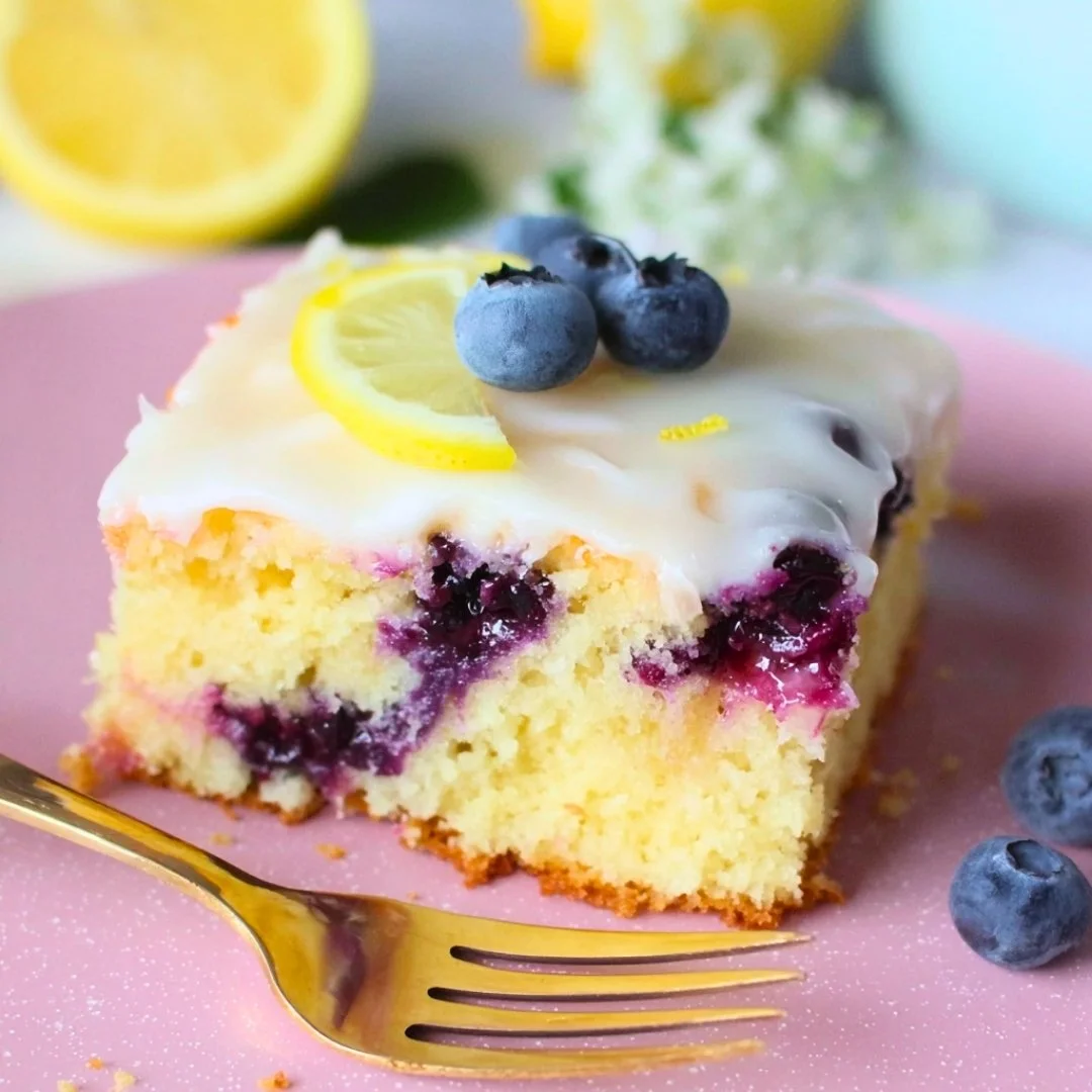 Delicious lemon blueberry sheet cake topped with fresh blueberries and lemon glaze.