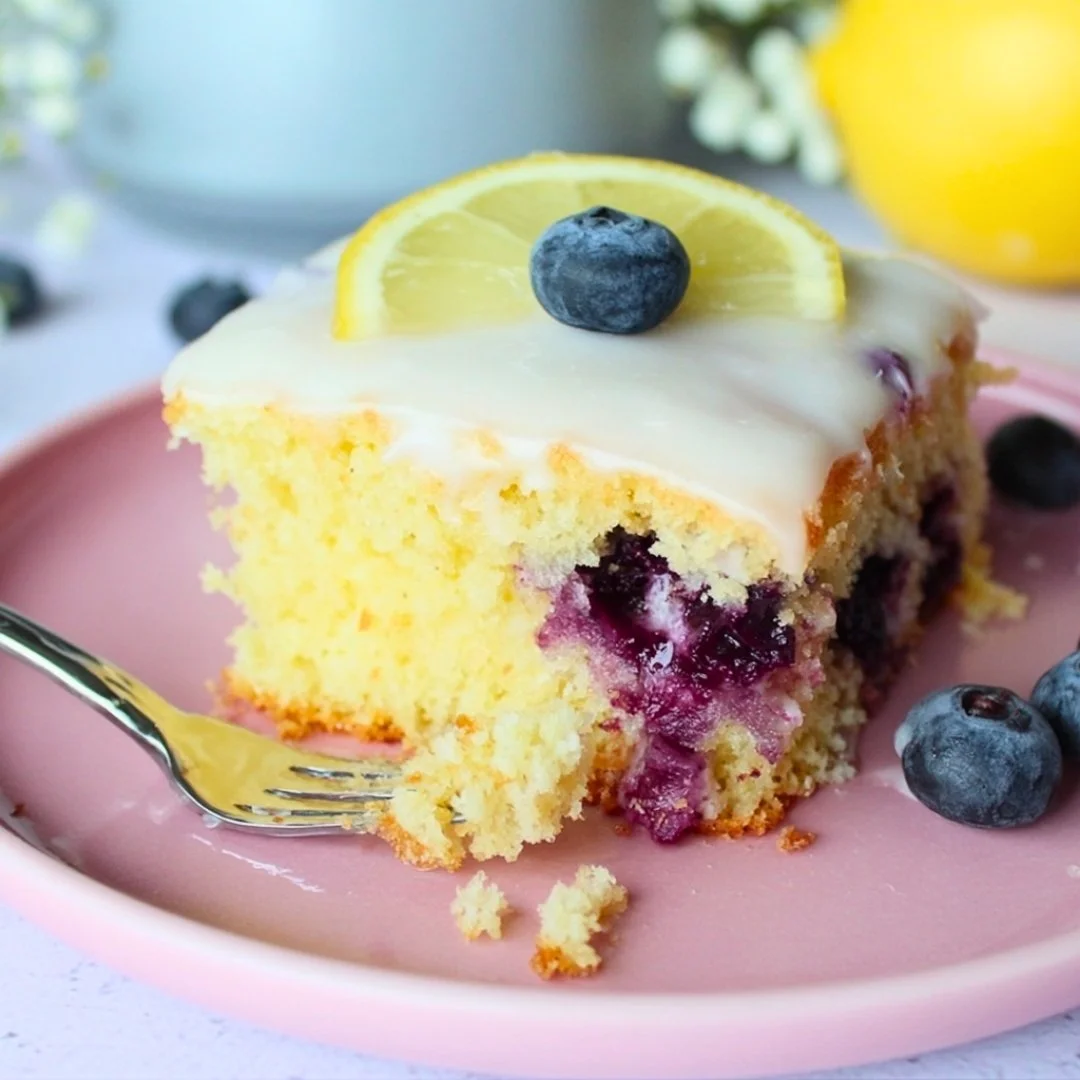 Lemon blueberry sheet cake topped with fresh blueberries and lemon zest