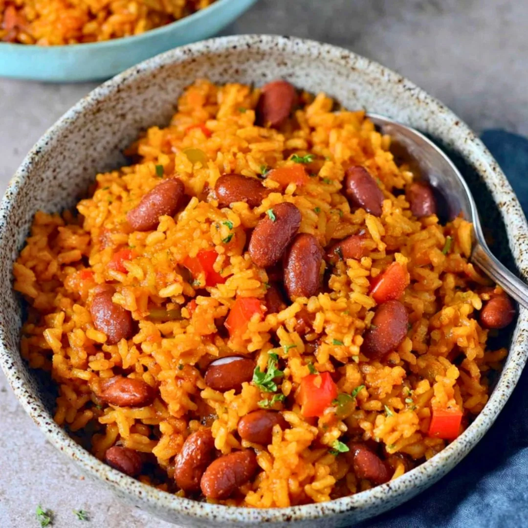 Plate of Spanish Rice and Beans garnished with herbs and spices.